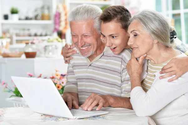 Szczęśliwa Para Starszy Wnuka Pomocą Laptopa Domu — Zdjęcie stockowe