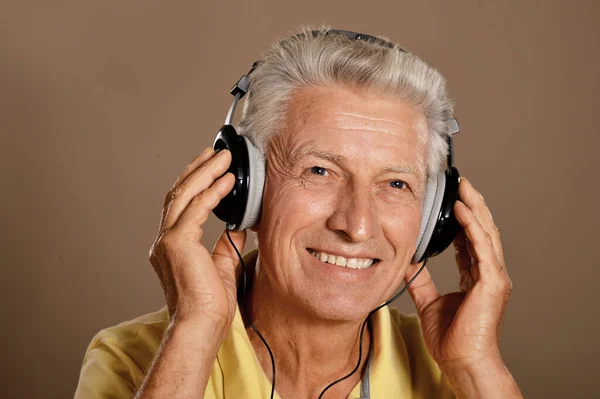 老年人在耳机里听音乐 — 图库照片