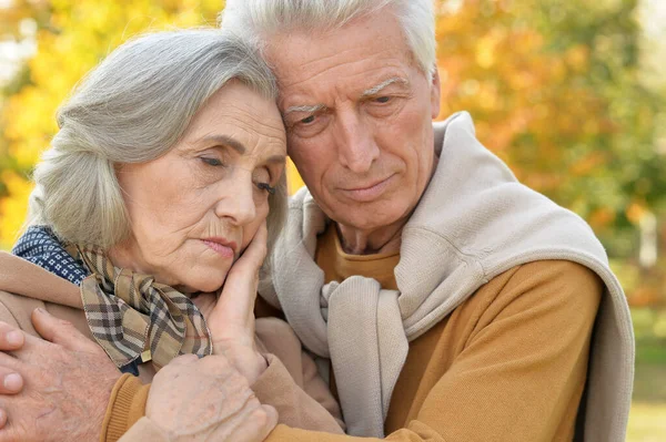 悲伤年长夫妇在片秋色的公园 — 图库照片