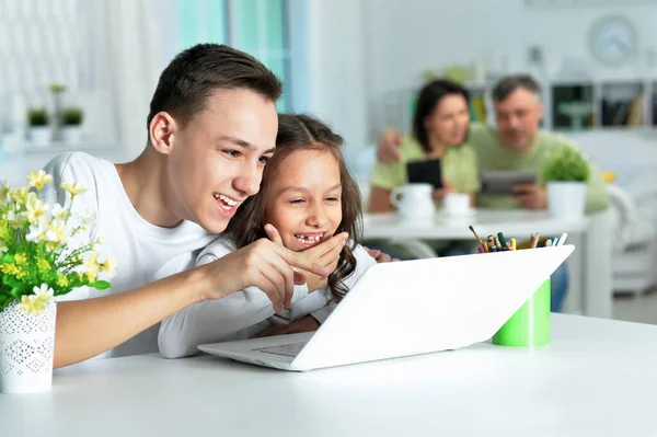 Broer Zus Met Behulp Van Laptop Terwijl Zitten Aan Tafel — Stockfoto