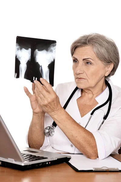 線を見るとコンピューターのテーブルに座って深刻な高齢者の女性の医者 — ストック写真
