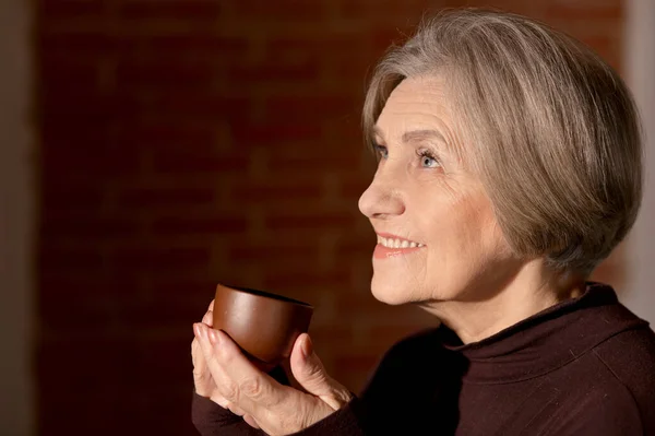 美しい笑顔の先輩女性がお茶を飲んで — ストック写真