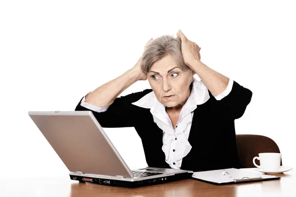 コンピューターのテーブルに座っている深刻な高齢者女性医師 — ストック写真
