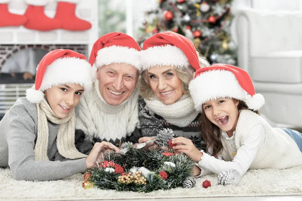 Yerde Noel Baba Şapkalı Mutlu Bir Ailenin Portresi — Stok fotoğraf