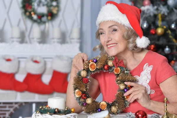 Porträt Einer Lächelnden Seniorin Mit Weihnachtsmütze Und Kranz — Stockfoto