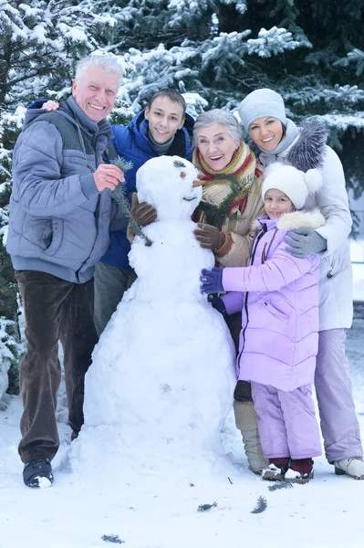 在雪地里快乐的家庭覆盖着冬天的森林 让雪人 — 图库照片