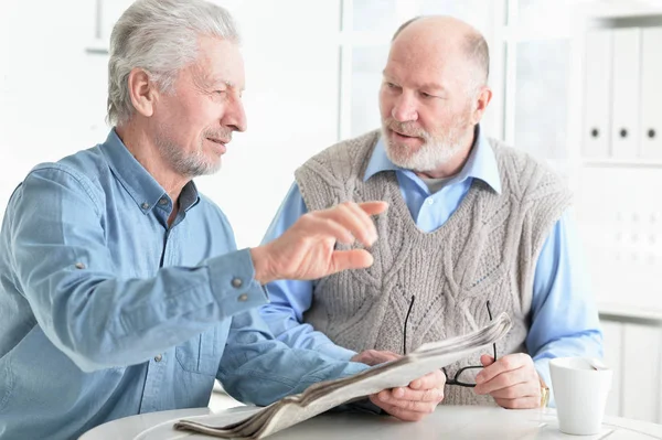 两个老年人坐在桌旁讨论新闻 — 图库照片