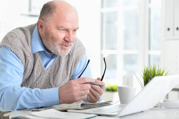 Senior Man Zoek Naar Laptop Terwijl Zitten Aan Tafel — Stockfoto