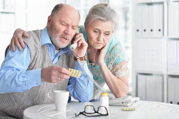 生病的高级夫妇与药片在家里打电话医生 — 图库照片
