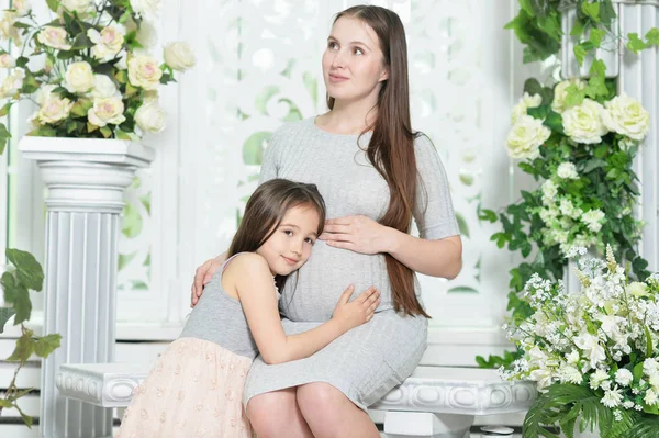 家でポーズの娘と幸せな妊娠中の女性 — ストック写真