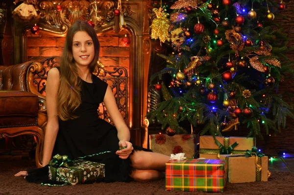 圣诞树旁带着礼物的快乐女孩的画像 — 图库照片