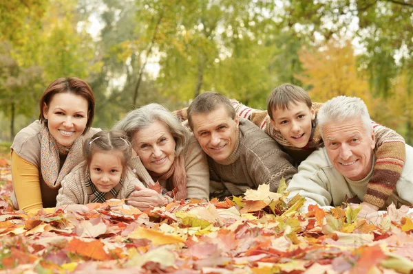 秋の公園でリラックスした幸せな笑みを浮かべて家族 — ストック写真