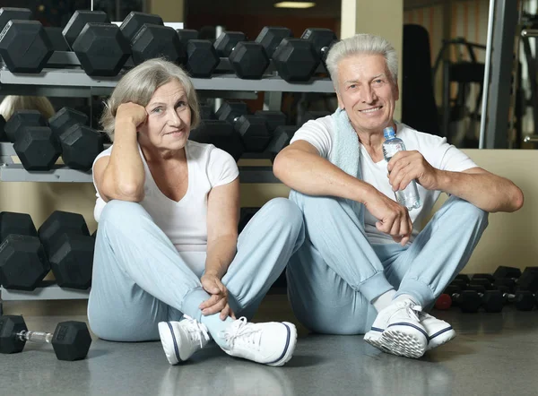 Senior couple drinking in gym — Stock Photo, Image