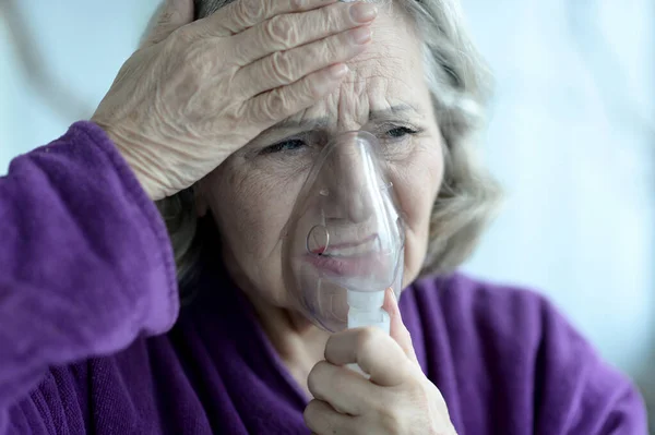 与流感吸入的老年妇女的肖像 — 图库照片