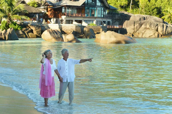 Happy Elderly Couple Tropical Beach Man Showing Spmething — Stock Photo, Image