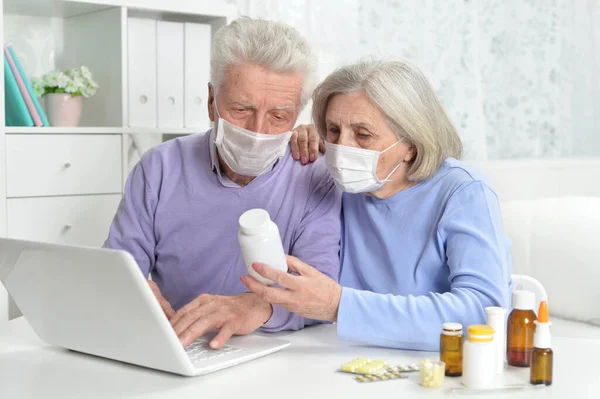 Krankes Senioren Paar Mit Gesichtsmasken Mit Laptop — Stockfoto