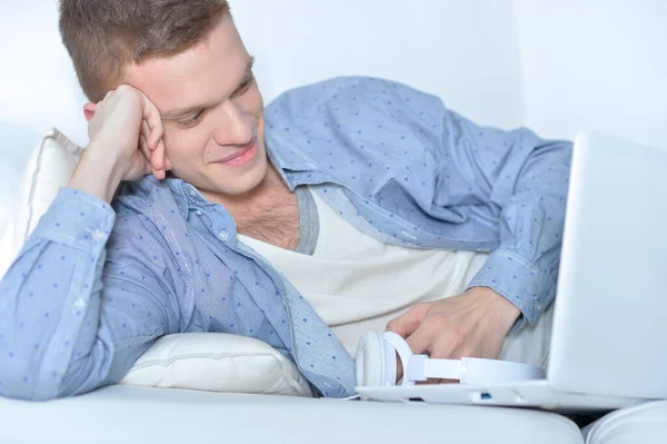 Beau Jeune Homme Couché Sur Canapé Blanc Avec Ordinateur Portable — Photo