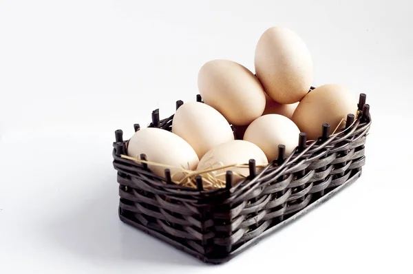 在白色背景上隔离的柳条篮中的新鲜鸡蛋 — 图库照片