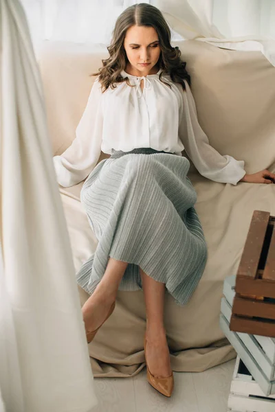 attractive businesswoman woman in formal wear sitting on sofa