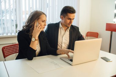 meslektaşları ile laptop ofiste masa başında otururken belge ile birlikte çalışma 