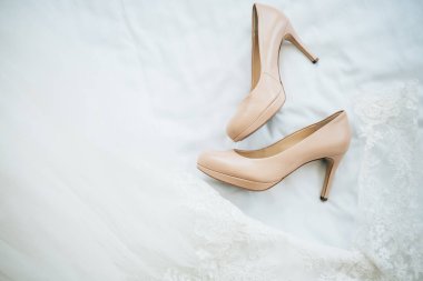 Beyaz gelinlik üzerinde bej zarif yüksek topuk ayakkabı 