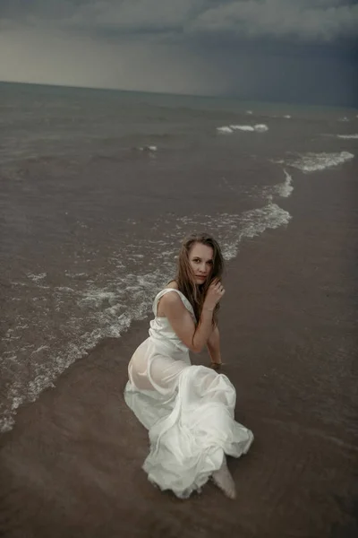 Fille en robe blanche dans la mer — Photo