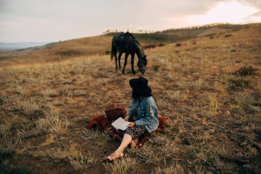 Mutlu kız gün batımında boho stilinde iyi vakit geçir. 