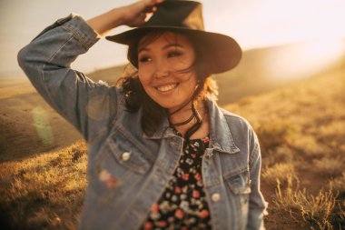 Mutlu kız gün batımında boho stilinde iyi vakit geçir. 