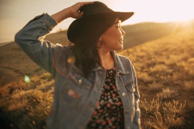 Mutlu kız gün batımında boho stilinde iyi vakit geçir. 