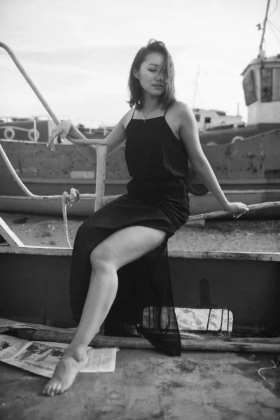 女性で黒のドレスでビーチで壊れた船 — ストック写真