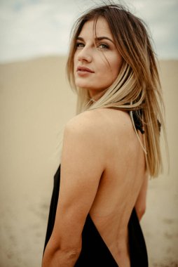 Çölde siyah elbiseli bir kadın