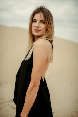 Çölde siyah elbiseli bir kadın