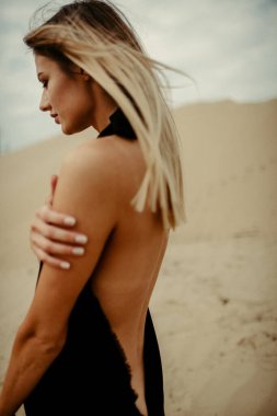 Çölde siyah elbiseli bir kadın