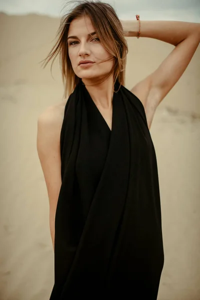 woman portrait in black dress in desert