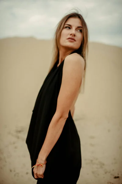 woman portrait in black dress in desert