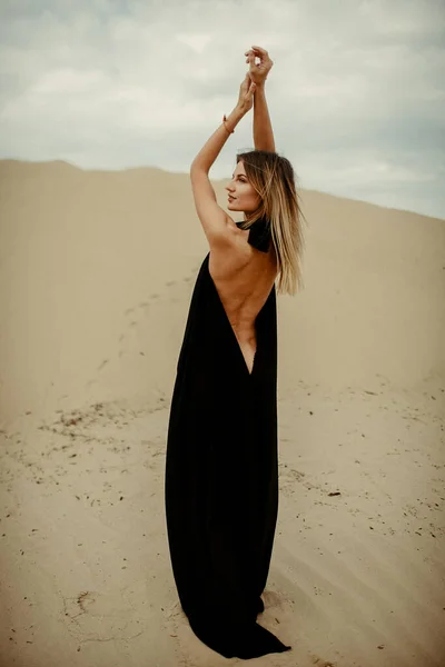 Woman in black dress in desert
