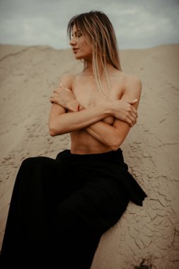 Çölde siyah elbiseli bir kadın 