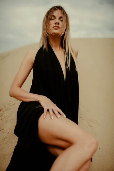 Woman in black dress in desert