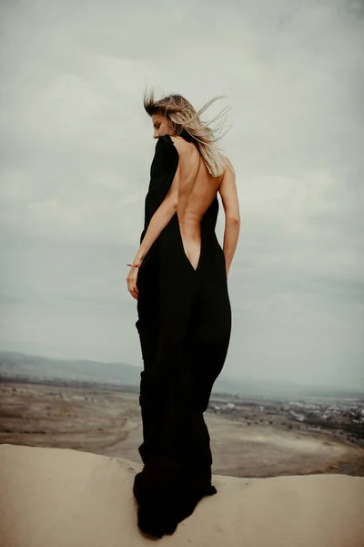 Woman in black dress in desert