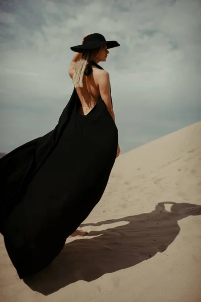 沙漠中穿黑色连衣裙的女孩 — 图库照片