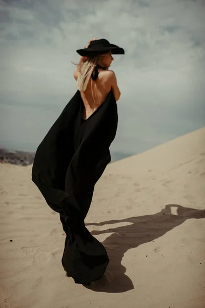 沙漠中穿黑色连衣裙的女孩 — 图库照片