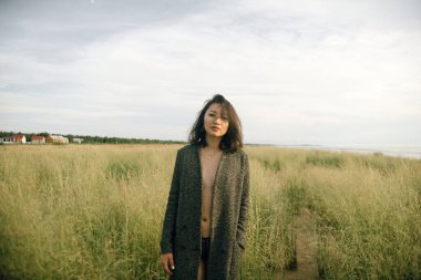 Plajda siyah elbiseli bir kadın kırık bir gemiyle