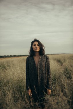 Plajda siyah elbiseli bir kadın kırık bir gemiyle