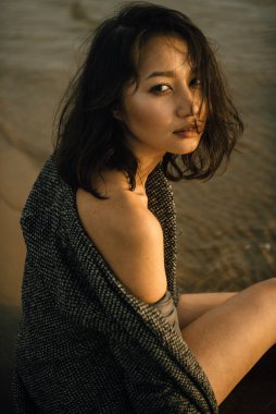 Plajda siyah elbiseli bir kadın kırık bir gemiyle