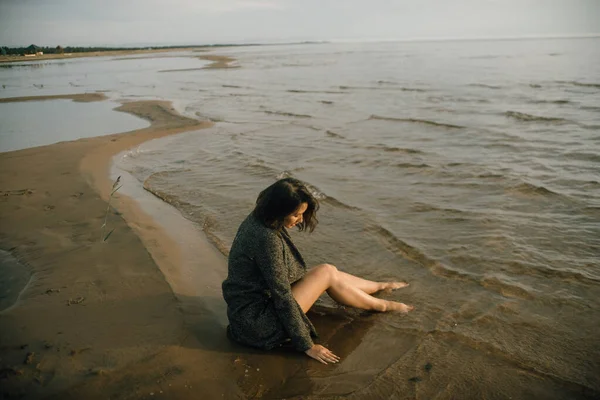 穿着黑色衣服的女人在海滩上与破碎的船 — 图库照片