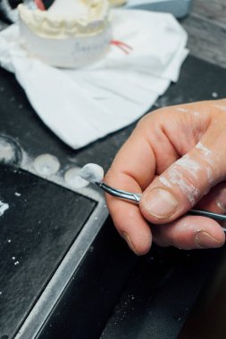 Diş teknisyeninin elleri bireysel alçı çene, yakın çekim, diş hekimliği ve süreç ayrıntıları kavramını oluşturan elleri  