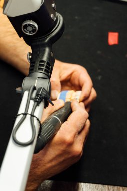 Diş teknisyeninin elleri bireysel alçı çene, yakın çekim, diş hekimliği ve süreç ayrıntıları kavramını oluşturan elleri  