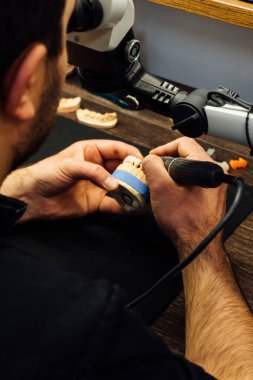 Diş teknisyeninin elleri bireysel alçı çene, yakın çekim, diş hekimliği ve süreç ayrıntıları kavramını oluşturan elleri  