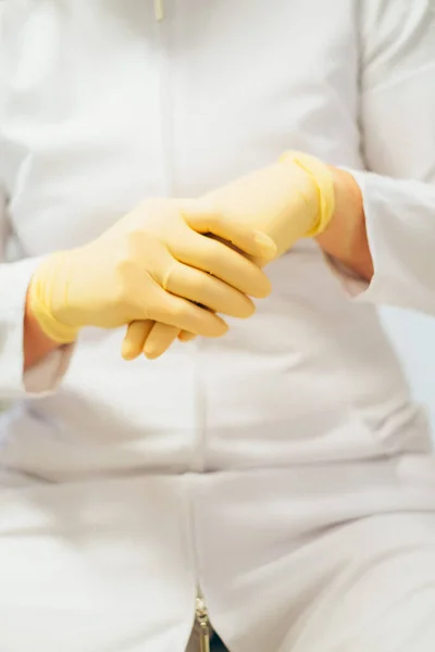 Dental  doctor putting medical gloves, close view