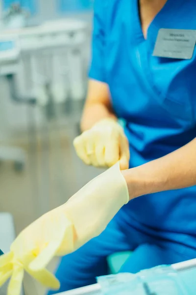 Dental  doctor putting medical gloves, close view